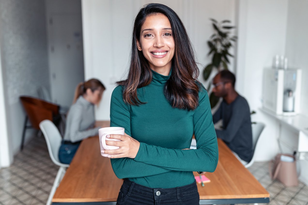 Young indian business woman entrepreneur looking at camera in the office.